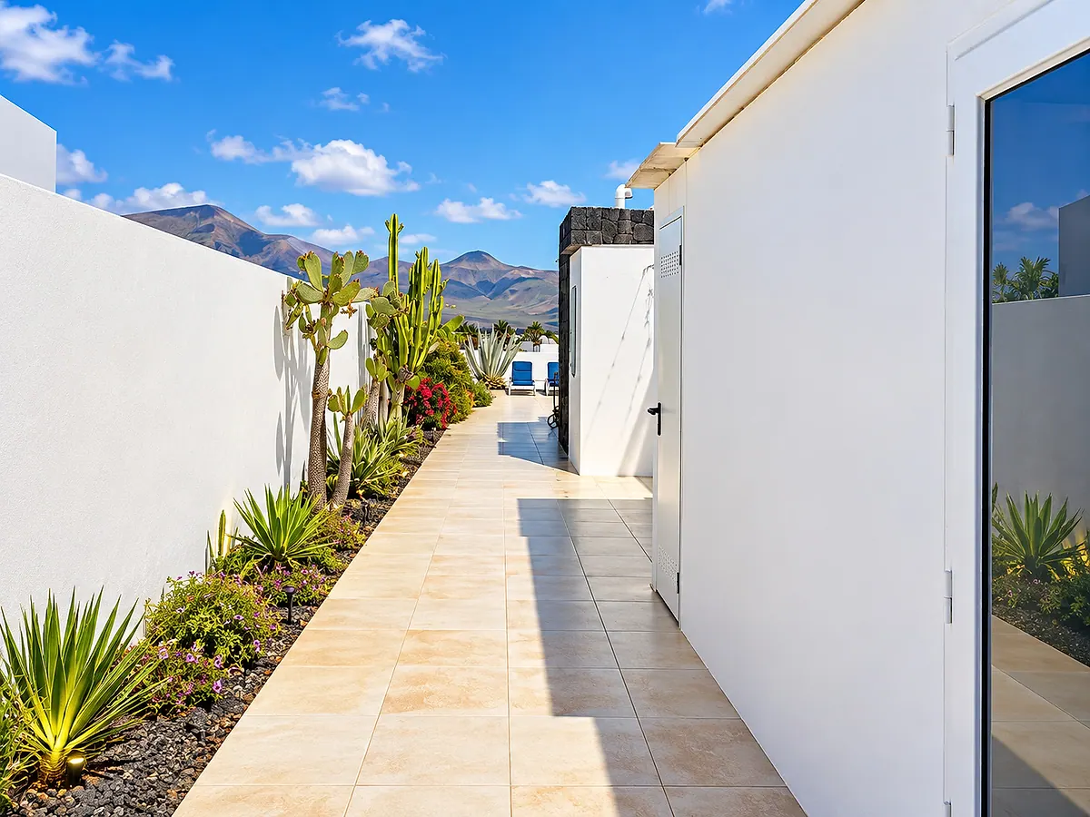 Landscaped outdoor walkway with cacti and mountains beyond