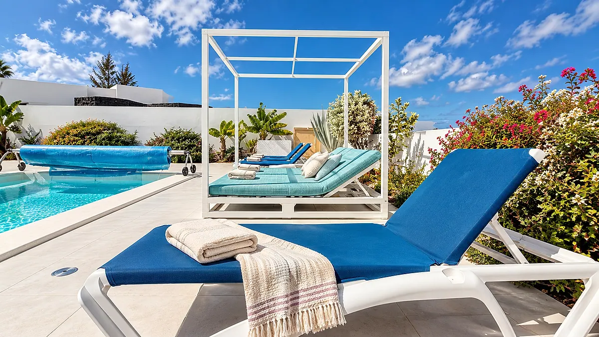 Blue sun lounger by the pool and a lounging area with turquoise cushions