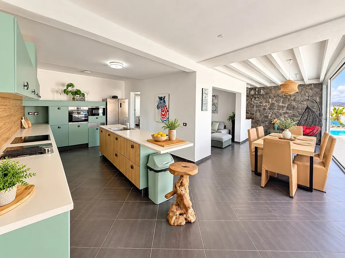 Aqua-green kitchen with central island, dining area and large window to the pool