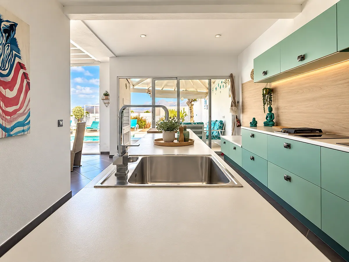 Equipped kitchen with hob and sink, terrace in the background