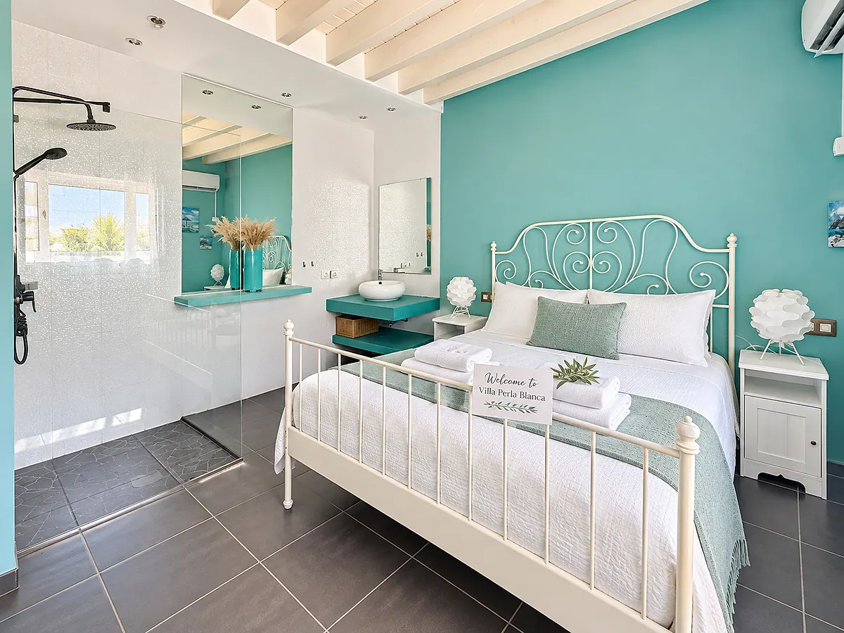 Turquoise bedroom with a white wrought-iron headboard